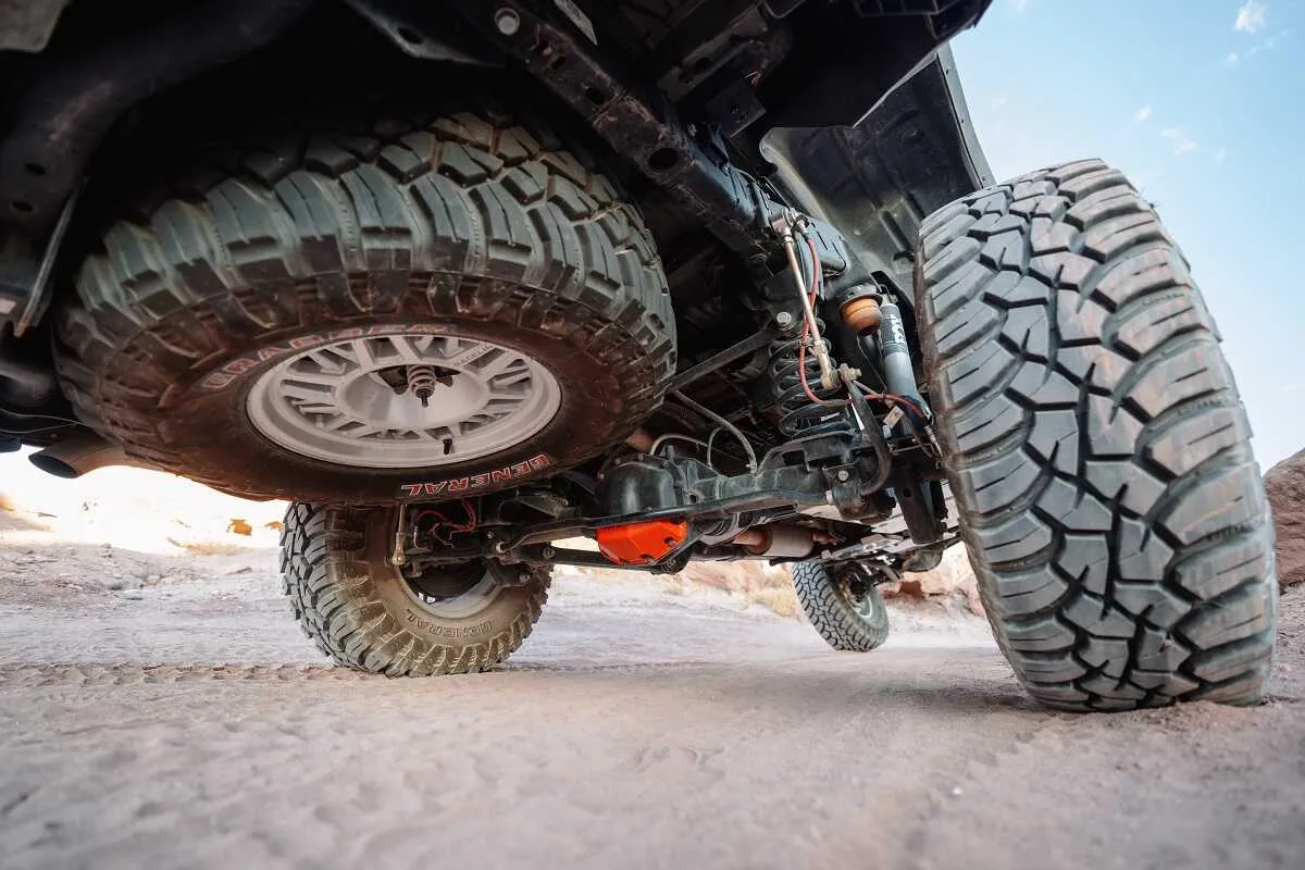 Off-road truck flexing with ASFIR skid plates and red diff guard